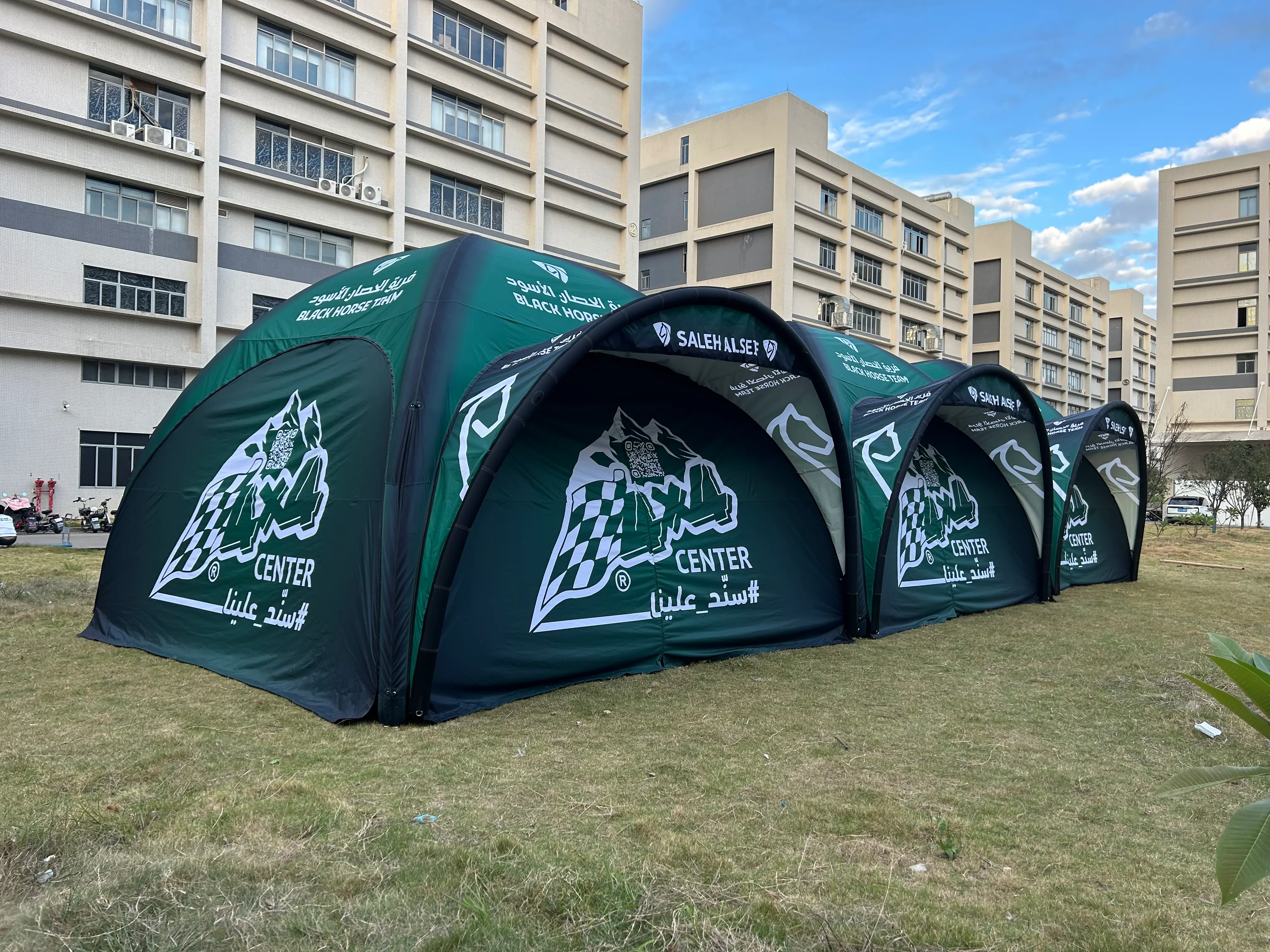 Side view of an inflatable pit tent with detachable sidewalls and high-contrast team logo printing.